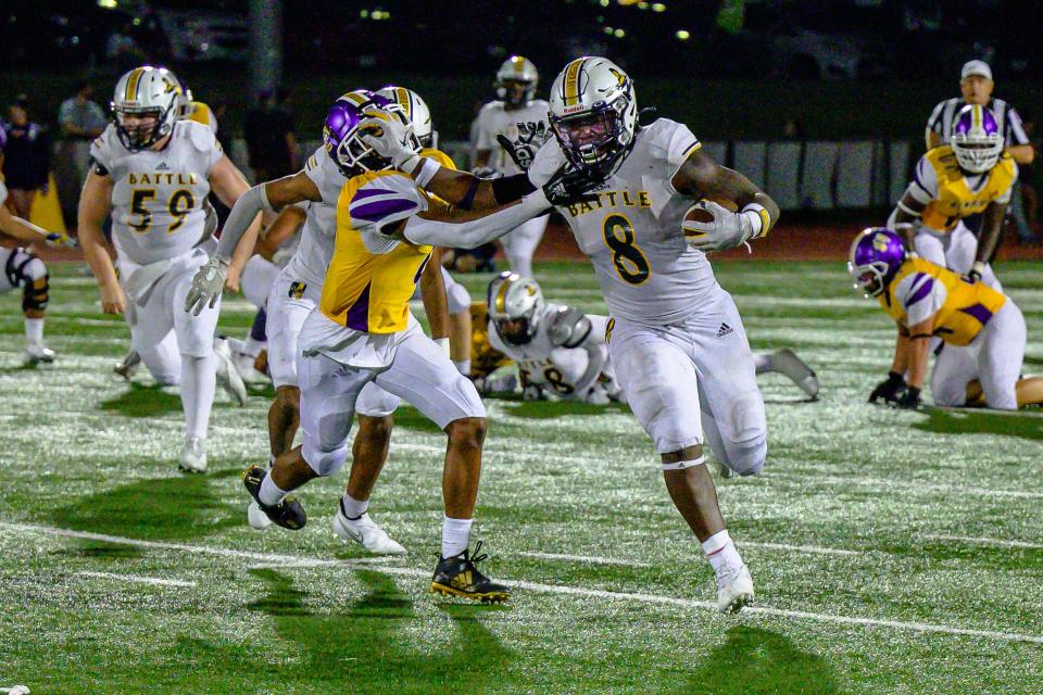 Battle's Rickie Dunn Jr. (8) stiff-arms Hickman's Darian Kemp (9) on a 57-yard run that set up a Spartans touchdown during Battle's 47-29 win over the Kewpies on Friday night.