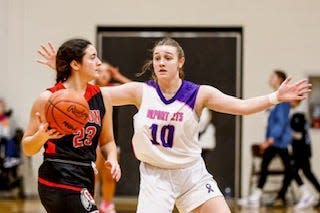 Airport's RaeAnn Drummond guards Lila Clements of New Boston Huron during the Coaches vs. Cancer basketball doubleheader at Airport Friday night.