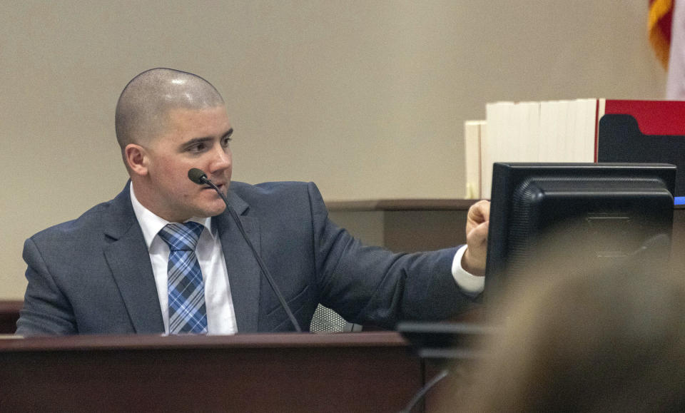 CORRECTION: REMOVES REFERENCE ABOUT OWNERSHIP OF GUN - FBI forensic examiner Bryce Ziegler looks at a picture of a firearm as he testifies during Hannah Gutierrez-Reed's trial at District Court, Monday, Feb. 26, 2024, in Santa Fe, N.M. Gutierrez-Reed is charged with involuntary manslaughter and tampering with evidence in the October 2021 death of cinematographer Halyna Hutchins during the filming of the Western “Rust”. (Luis Sánchez Saturno/Santa Fe New Mexican via AP, Pool)