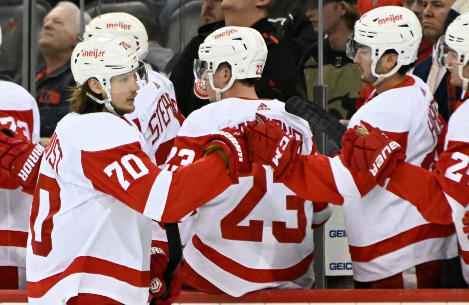 Detroit Red Wings center Oskar Sundqvist (70) celebrates his goal with teammates during the first period of an NHL hockey game against the New Jersey Devils Sunday, April 24, 2022, in Newark, N.J.