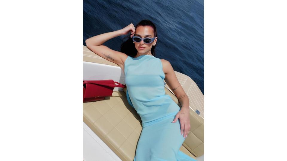 Dua Lipa wears a blue dress on a boat in Italy