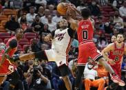 Miami Heat forward P.J. Tucker (17) and Chicago Bulls guard Coby White (0) go after tje ball during the first half of an NBA basketball game Monday, Feb. 28, 2022, in Miami. (AP Photo/Marta Lavandier)