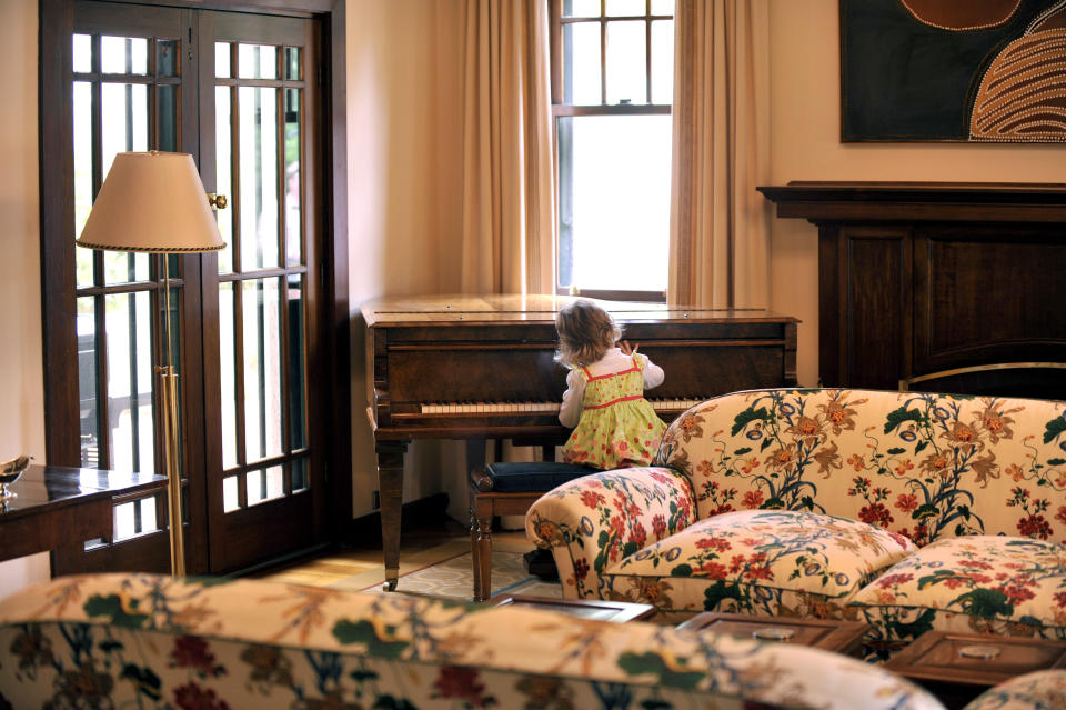 3 year old Una Rose O'Connor, the daughter of then-Minister for Home Affairs Brendan O'Connor, tinkles with the piano during a morning tea at the Lodge in Canberra, Tuesday, Feb. 8, 2011. (AAP Image/Alan Porritt)