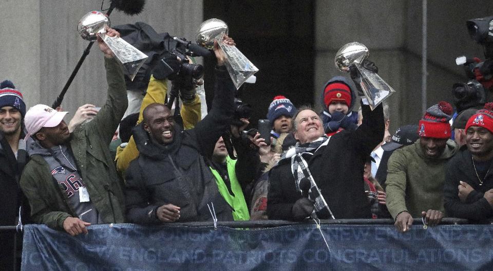 El entrenador de los Patriots de Nueva Inglaterra, Bill Belichick (derecha), alza un trofeo del Super Bowl durante el desfile conmemorativo realizado el martes 7 de febrero de 2017 en Boston (Barry Chin /The Boston Globe via AP, Pool)