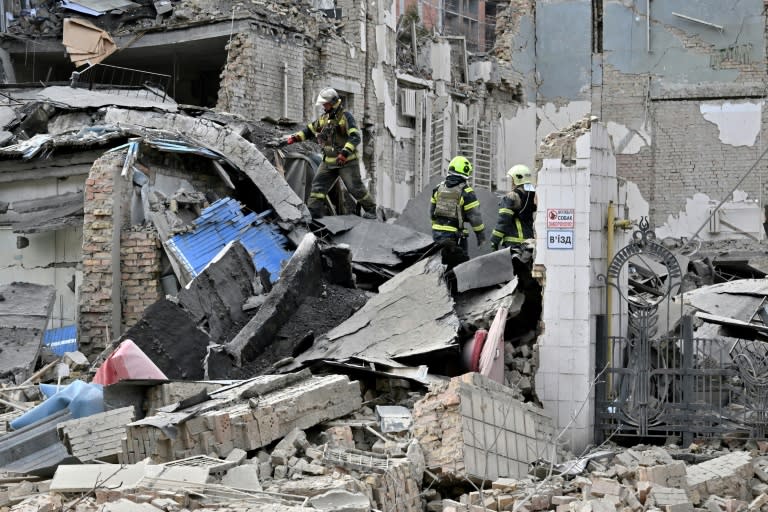 Des sauveteurs ukrainiens sur le site d'une attaque de missiles russes à Kiev, le 25 mars 2024 (Sergei SUPINSKY)