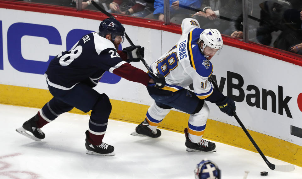 St. Louis Blues center Robert Thomas, right, collects the puck as Colorado Avalanche defenseman Ian Cole covers in the first period of an NHL hockey game Saturday, Jan. 18, 2020, in Denver. (AP Photo/David Zalubowski)