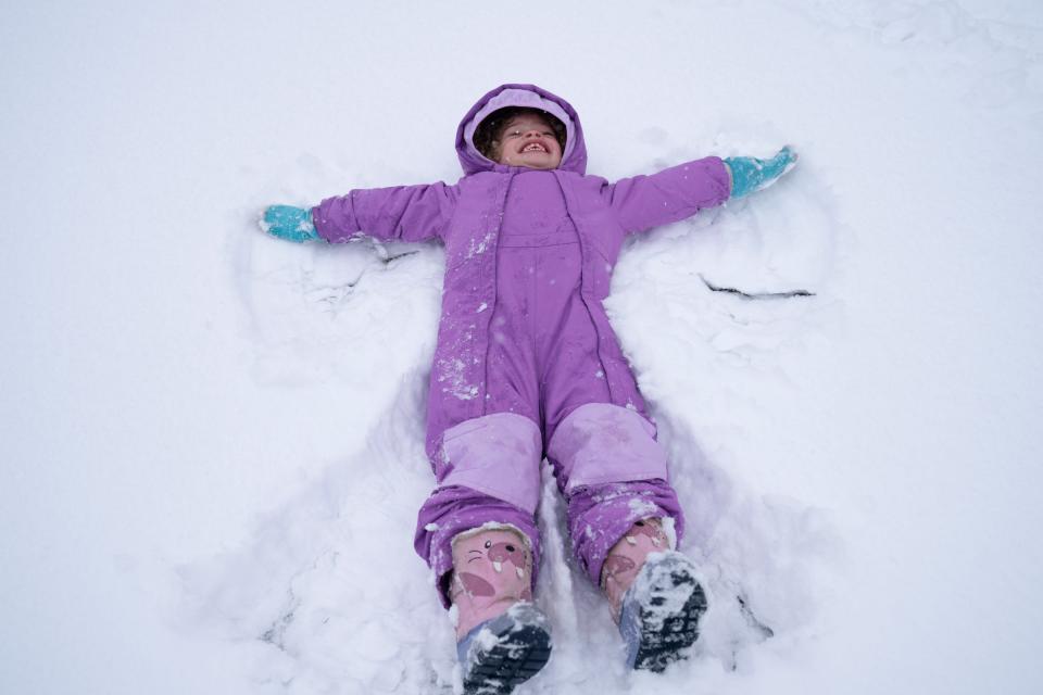 Luna Blandford, 3, makes snow angels at Hyde Park in the snow on Friday, March 10, 2023. Blandford's mom, Kellie, had to go to work at 2 and was happy to play with Luna, who had a snow day from preschool.