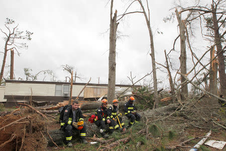 A Georgia Search and Rescue team takes a break at the Big Pine Estates Mobile Home Park after a tornado struck the residential area in Albany, Georgia. REUTERS/Tami Chappell