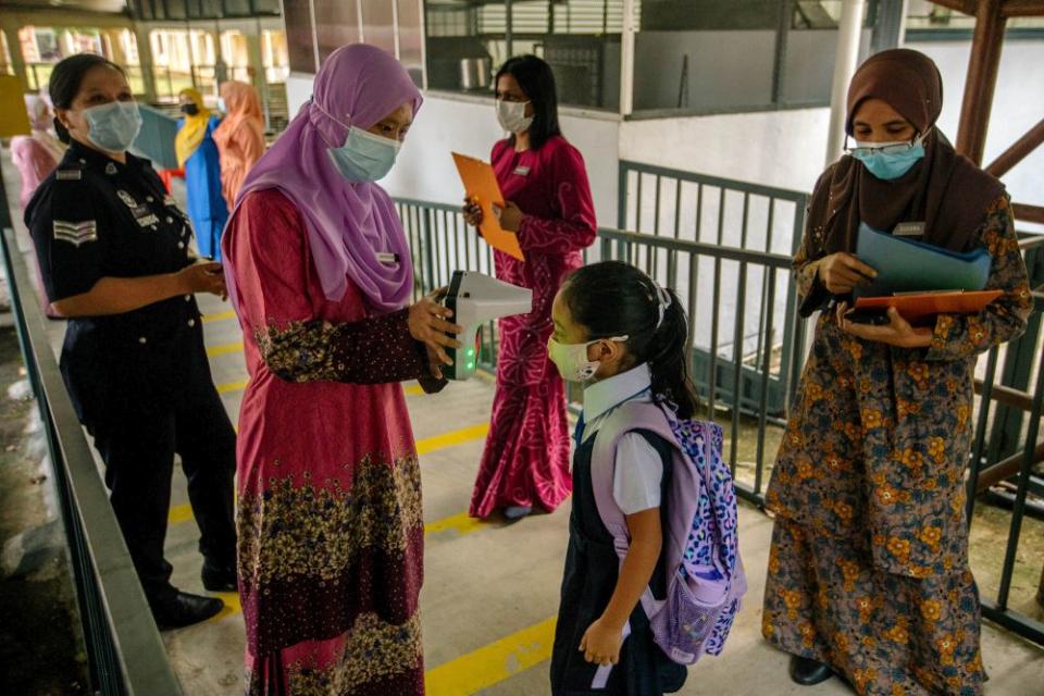 A Sekolah Kebangsaan Convent (2) Bukit Nanas student has her temperature checked on her first day back at school in Kuala Lumpur March 1, 2021. — Picture by Firdaus Latif