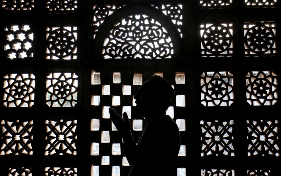 A Muslim man prays inside a shrine during the holy fasting month of Ramadan in Ahmedabad - Amit Dave/Reuters