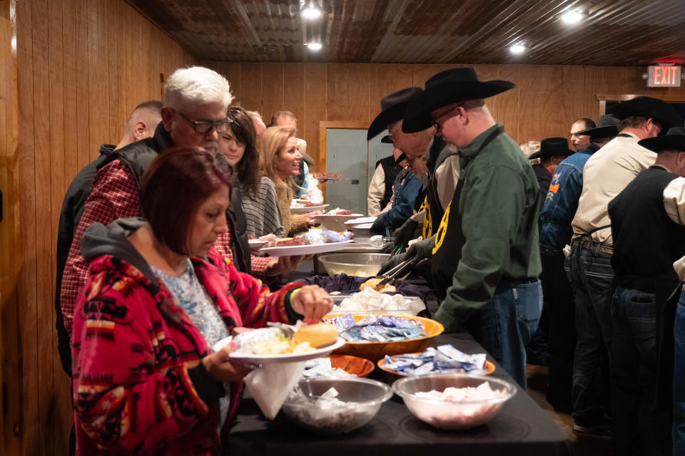 Attendees line up for dinner served by the Coors Cowboy Club Saturday at the 100 Club of the Texas Panhandle's annual Bandfest in Bushland.