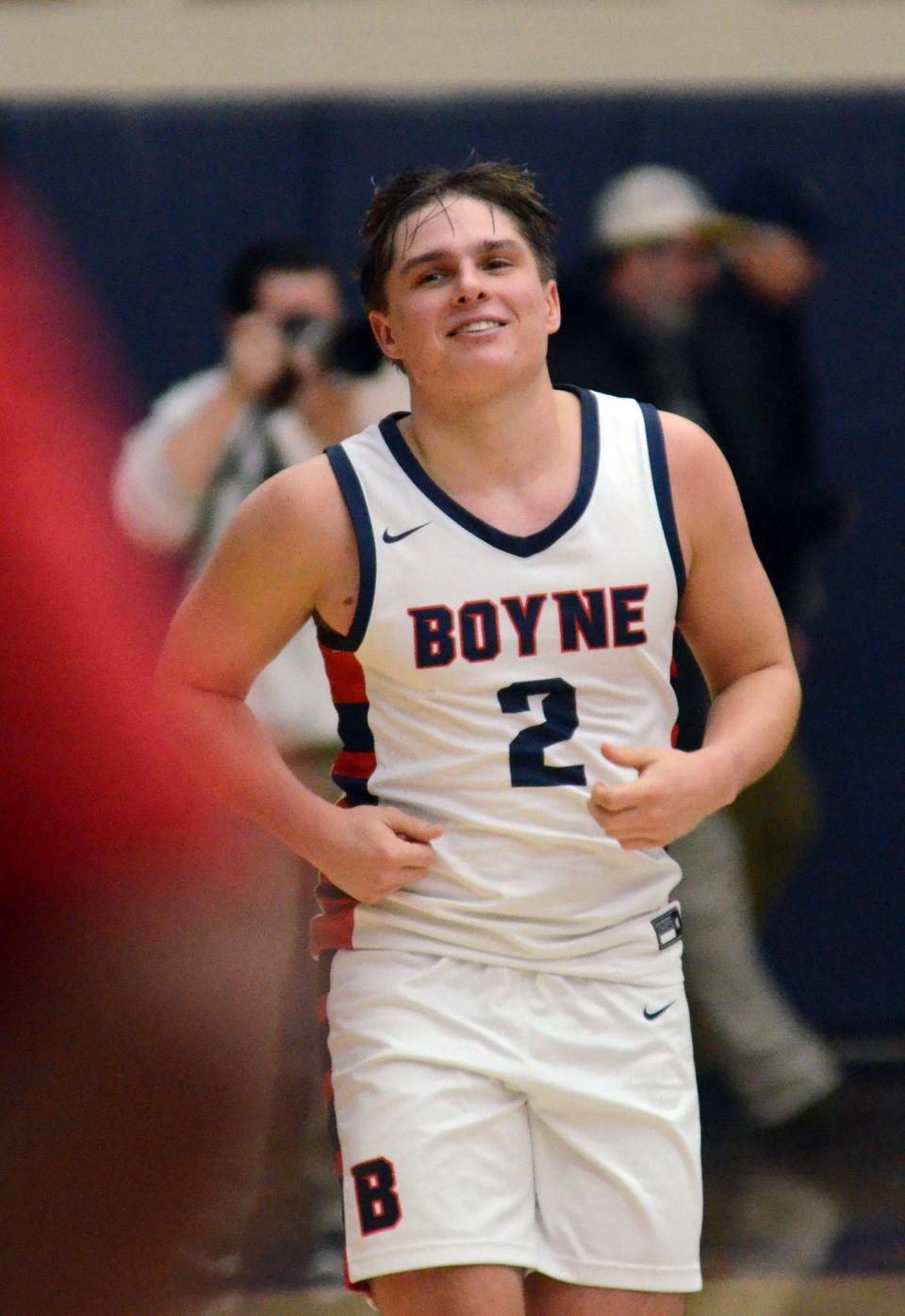 Boyne City's Jack Neer runs to the hand shaking line following a celebration on the court after the final buzzer.