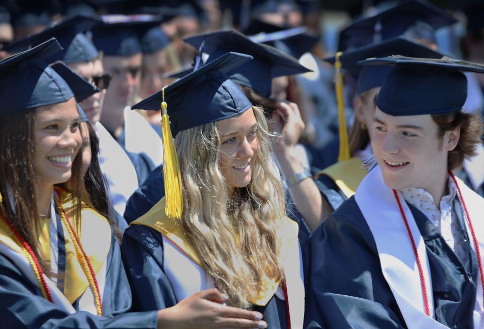 Class of 2022 President Sarah McCormick listens as she is called to the stage to speak during the graduation ceremony Saturday, June 4, 2022, at Plymouth North High School. At left is salutatorian Nathalie Carlon, and at right is class Vice President Alec MacLeod.