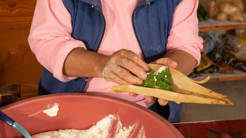 Chef using her hands to fill a tamale