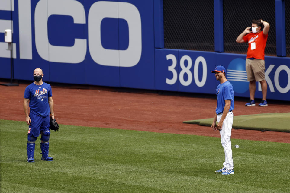 New York Mets pitcher Jacob deGrom, right, laughs during a baseball workout at Citi Field in New York, Friday, July 3, 2020. (AP Photo/Adam Hunger)