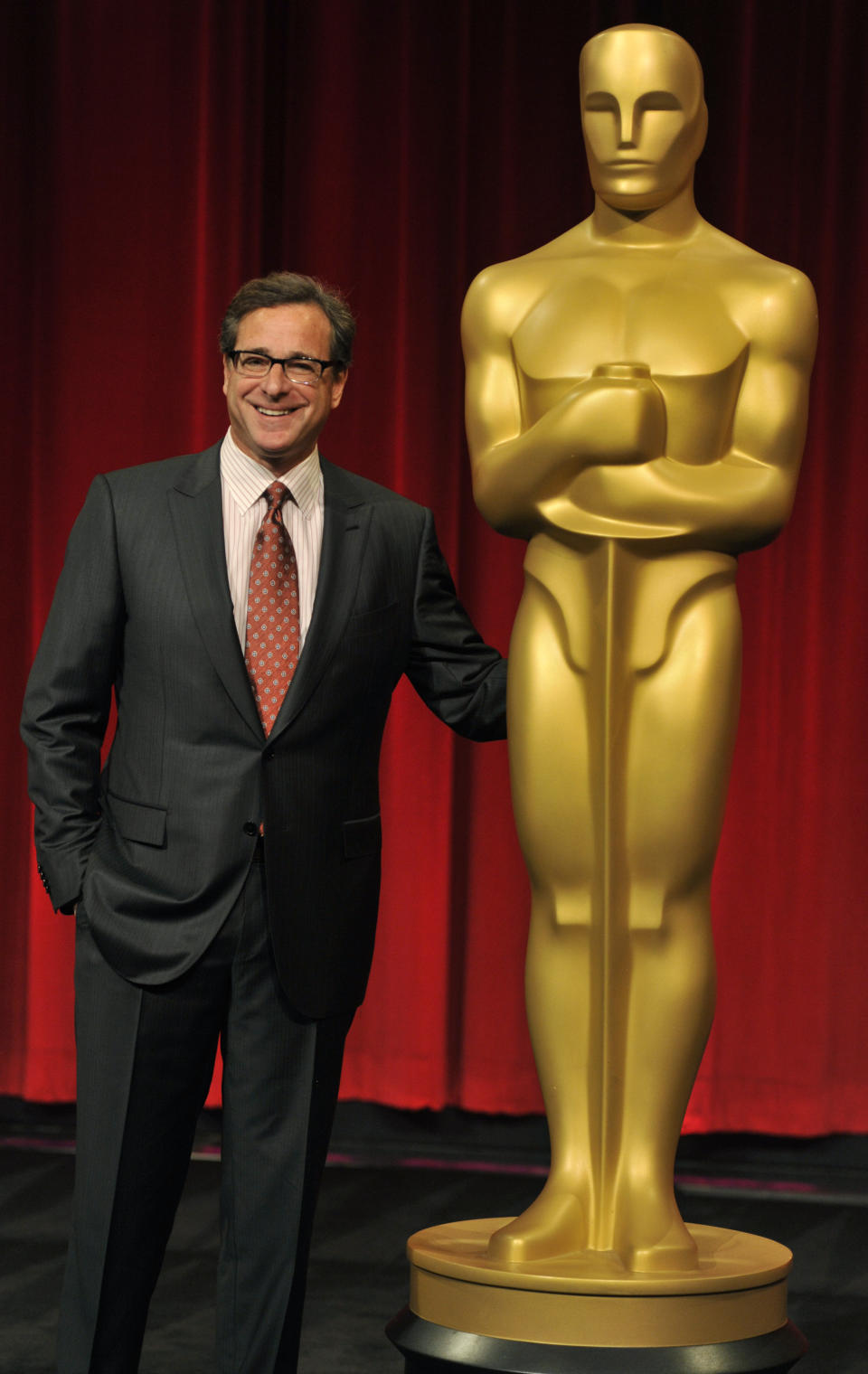 FILE - Host Bob Saget poses alongside an Oscar statue before the Academy of Motion Picture Arts and Sciences 40th Student Academy Awards at the Samuel Goldwyn Theater on Saturday, June 8, 2013, in Beverly Hills, Calif. Saget, a comedian and actor known for his role as a widower raising a trio of daughters in the sitcom “Full House,” has died, according to authorities in Florida, Sunday, Jan. 9, 2022. He was 65. (Photo by Chris Pizzello/Invision/AP, File)