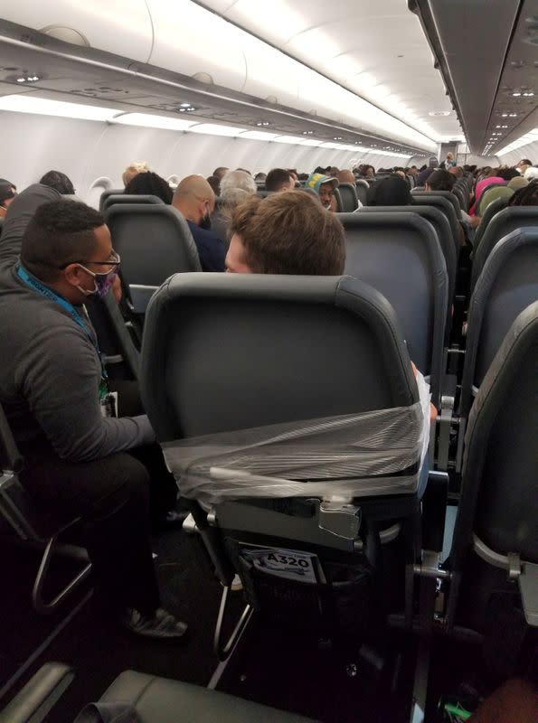 A man sits taped to a seat on a Frontier Airlines flight from Philadelphia to Miami