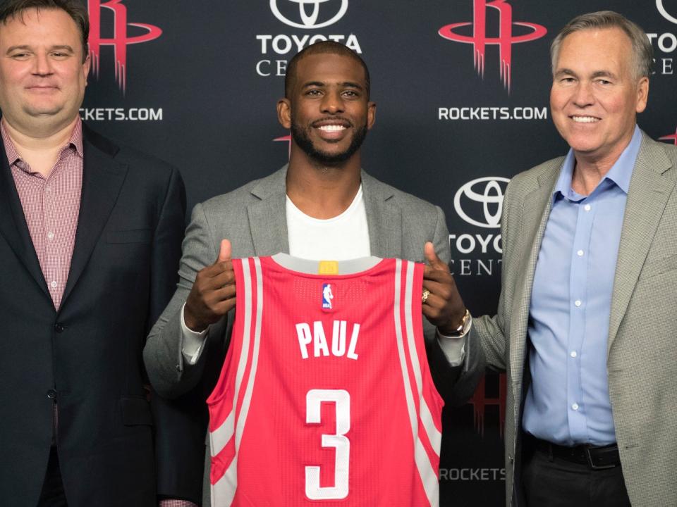 Chris Paul holds up a Rockets jersey at his introductory press conference in 2017.