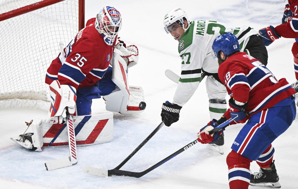 Dallas Stars' Mason Marchment (27) moves in on Montreal Canadiens goaltender Sam Montembeault as Canadiens' David Savard (58) defends during second period NHL hockey action in Montreal, Canada, Saturday, Feb. 10, 2024. (Graham Hughes/The Canadian Press via AP)