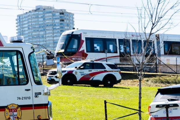 Emergency vehicles are parked near the scene of a derailed LRT train in Ottawa on Sunday. (Nicholas Cleroux/Radio-Canada - image credit)