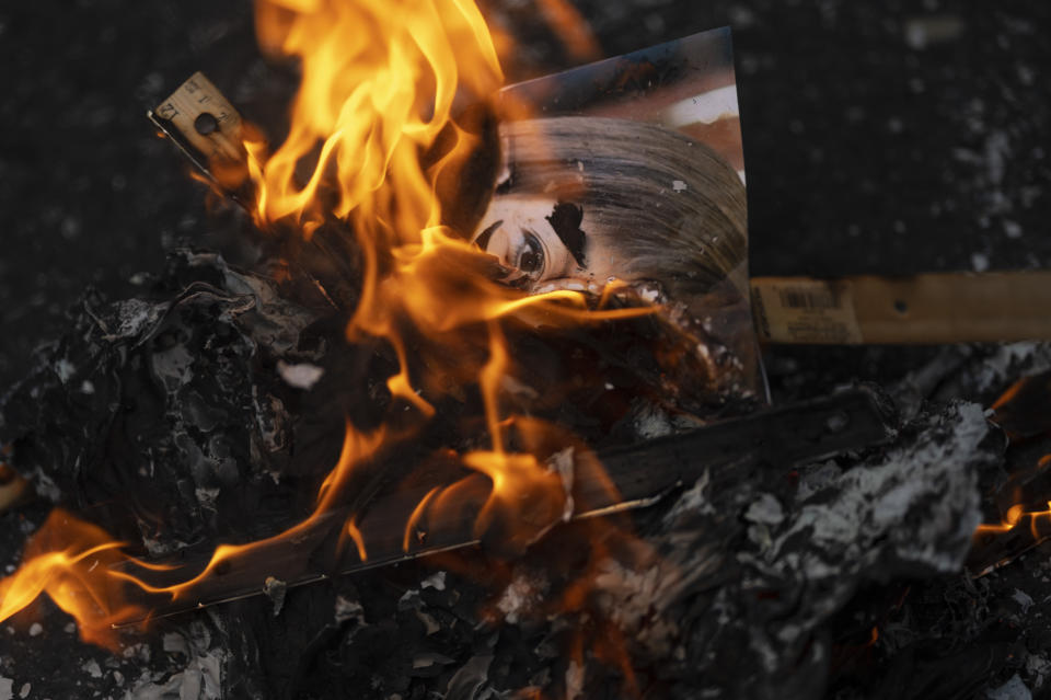 A picture of Natalie Jaresko, executive director of the financial oversight and management board for Puerto Rico, is burned by demonstrators protesting the Debt Adjustment Plan outside the federal court where it is being considered by a bankruptcy judge in San Juan, Puerto Rico, Monday, Nov. 8, 2021. Puerto Rico’s Senate and House approved a bill two weeks prior that would slash the central government's debt by half, but critics say the government does not have the finances to adhere to the proposed debt service and warn of upcoming austerity measures. (AP Photo/Carlos Giusti)