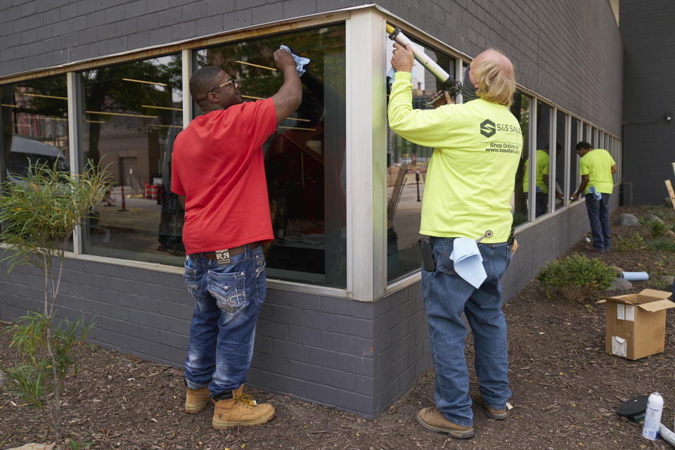 Workers replace windows smashed in May 2020, at a business in downtown Omaha, Neb., Wednesday, Sept. 16, 2020, one day after a grand jury decided to charge a white business owner who fatally shot Black James Scurlock during civil unrest in downtown Omaha this spring with manslaughter and other charges. This week's decision to charge Jake Gardner, a white bar owner who fatally shot James Scurlock, a Black man, during a chaotic night of protests in downtown Omaha months after the shooting was initially deemed self-defense highlights how difficult it can be to sort out these cases. (AP Photo/Nati Harnik)