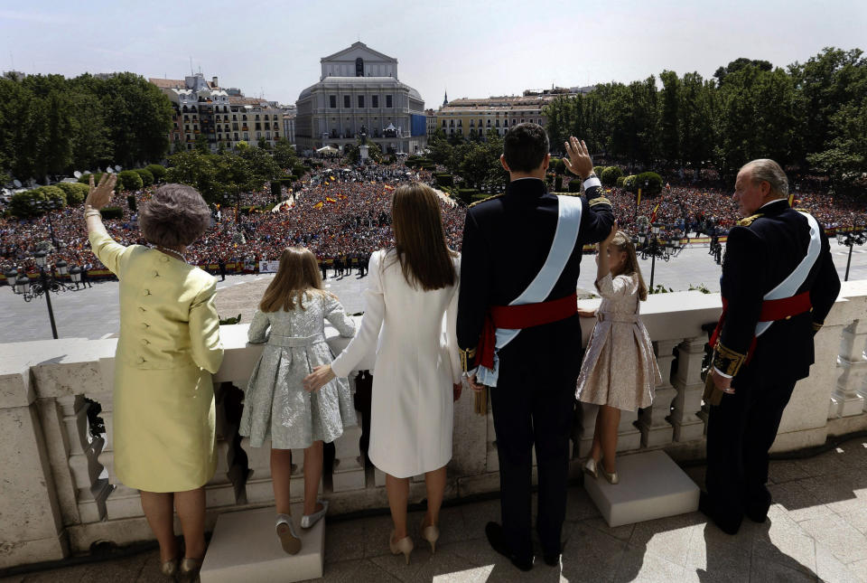 Spain’s newly crowned King Felipe VI, third right, his father Juan Carlos, right, his mother Sofia, left, his wife Spain's Queen Letizia, third left, and his daughters Spain's Princess Leonor, second right, and Spain's Princess Sofia, second left, wave from a balcony of the Royal Palace in Madrid, Spain, Thursday June 19, 2014. Felipe's father Juan Carlos, who reigned for four decades, stepped down after signing an abdication law Wednesday so that younger royal blood can rally a country beset by economic problems, including an unemployment rate of 25 percent. (AP Photo/Javier Lizon, Pool)