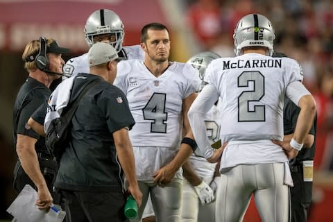 Oakland Raiders head coach Jon Gruden (far left), quarterback Derek Carr (4), and quarterback AJ McCarron (2) talk during the fourth quarter against the San Francisco 49ers - Credit: Kyle Terada/USA Today