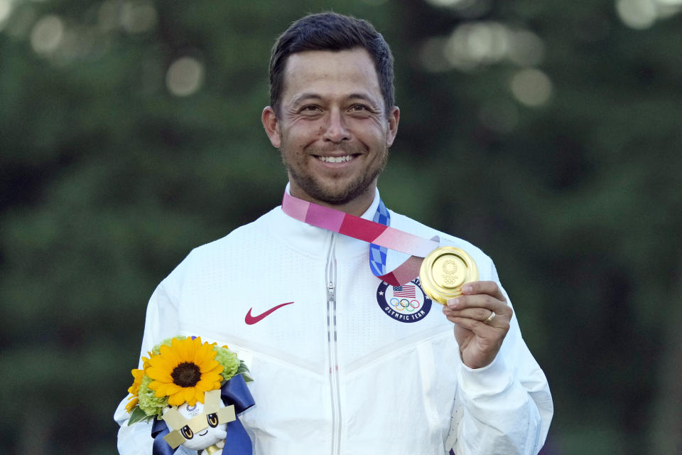 FILE - In this Aug. 1, 2021, file photo, Xander Schauffele, of the United States, holds his gold medal in the men's golf at the 2020 Summer Olympics in Kawagoe, Japan. The 2020 US Ryder Cup team has six rookies, including gold medalist Xander Schauffele. (AP Photo/Andy Wong, File)