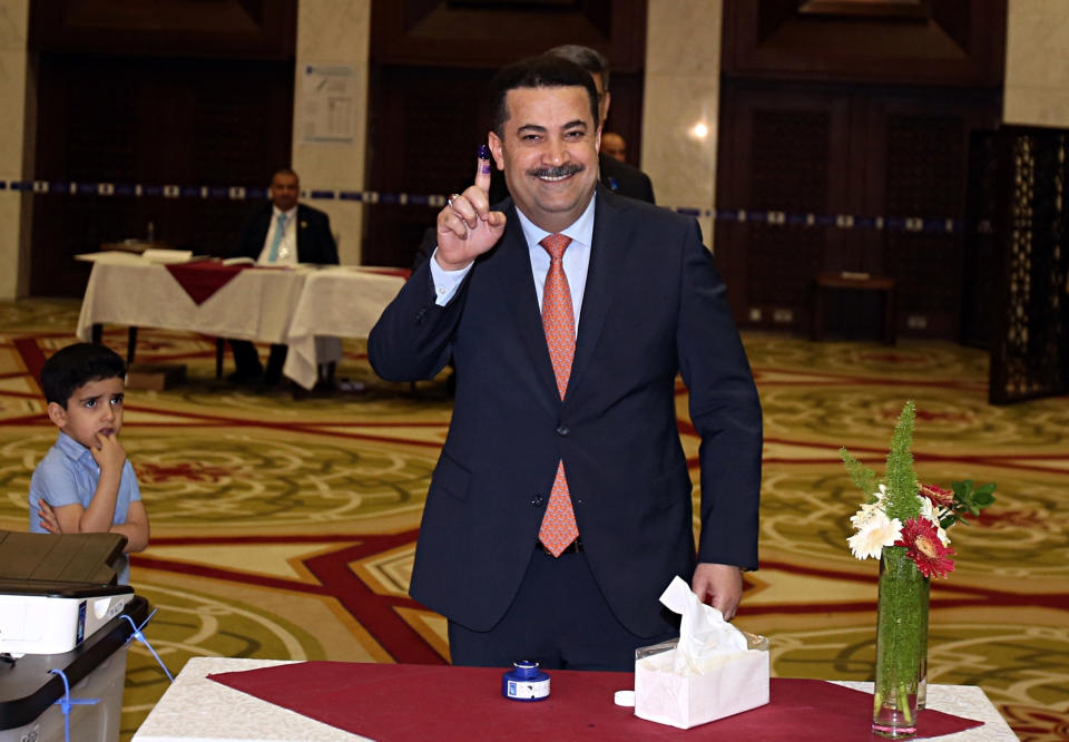 FILE - Mohammed al-Sudani, Minister of Labor and Social Affairs shows his ink-stained finger after casting his vote in the country's parliamentary elections in the heavily fortified Green Zone in Baghdad, Iraq, May 12, 2018. Hundreds of demonstrators reached the gate of Baghdad's heavily fortified Green Zone on Wednesday, July 27, 2022, to protest the recent nomination of al-Sudani for prime minister by Iran-backed political groups. (AP Photo/Karim Kadim, File)