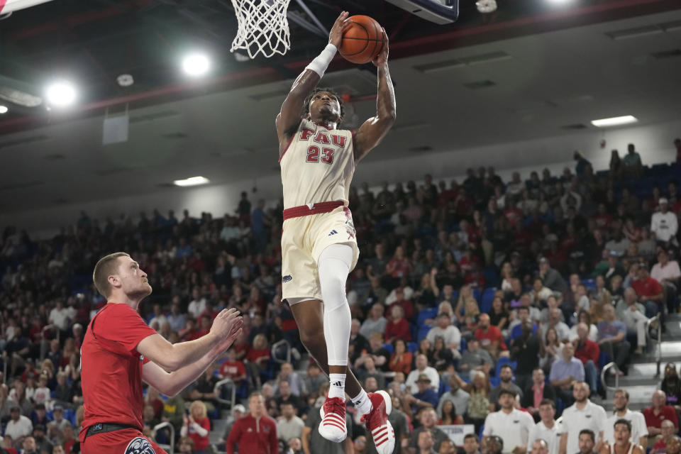 Florida Atlantic guard Brandon Weatherspoon (23) shoots as Liberty forward Bryson Spell, left, defends during the second half of an NCAA college basketball game, Thursday, Nov. 30, 2023, in Boca Raton, Fla. (AP Photo/Lynne Sladky)