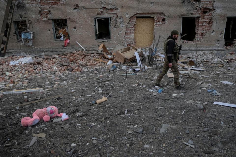 A Ukrainian serviceman walks near destroyed building in the frontline town of Chasiv Yar (Reuters)