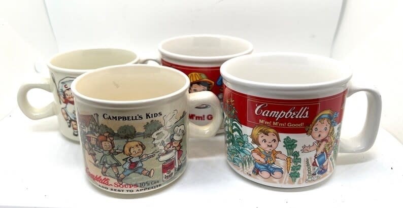 Collection of four vintage Campbell's soup mugs with various illustrations of the Campbell Kids characters