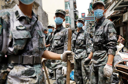 People’s Liberation Army (PLA) soldiers react as they clean debris after Typhoon Hato hits in Macau, China August 25, 2017. REUTERS/Tyrone Siu
