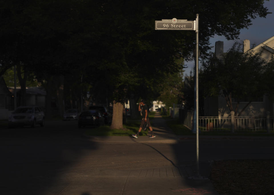 A man walks down 96 Street, or "Church Street" as it's also named, on Monday, July 18, 2022, in Edmonton, Alberta. (AP Photo/Jessie Wardarski)