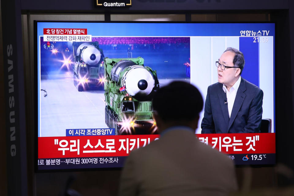 A man watches a television showing North Korea's military parade at the Seoul Railway Station.