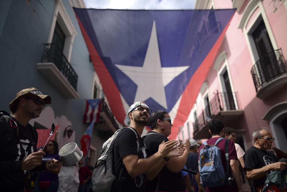 People protest outside the executive mansion known has La Fortaleza in Old San Juan demanding the resignation of Governor Wanda Vázquez Garced after the discovery of an old warehouse filled with emergency supplies in San Juan, Puerto Rico, Monday, Jan. 20, 2020. Anger erupted in Puerto Rico on Saturday after an online blogger posted a live video of the warehouse in the southern coastal city of Ponce filled with water bottles, cots, baby food and other basic supplies that had apparently been sitting there since Hurricane Maria battered the U.S. territory in September 2017. (AP Photo/Carlos Giusti)