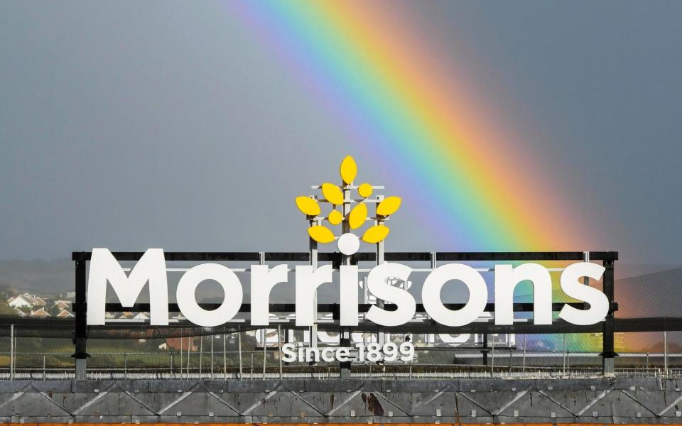 A rainbow arches up into the sky above a Morrisons supermarket sign - Graham Hunt /Alamy Live News