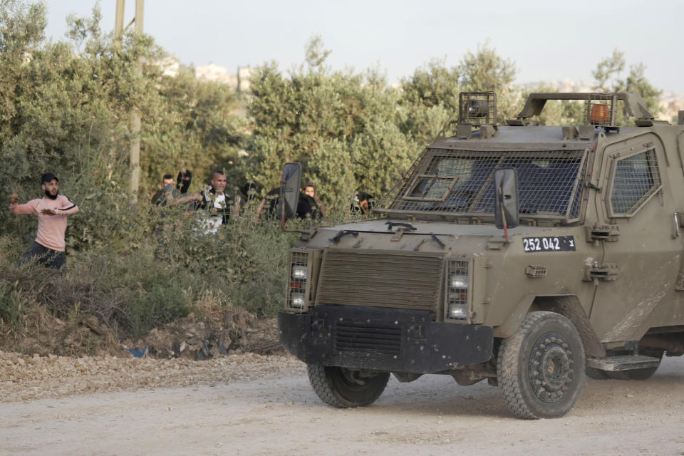 Palestinians throw rocks during clashes with Israeli soldiers, in the West Bank village of Silat al-Harithiya, near Jenin, Saturday, May 7, 2022, as Israeli forces demolished the home of Omar Jaradat was part of a group who shot and killed yeshiva student Yehuda Dimentman in the West Bank in December 2021. (AP Photo/Majdi Mohammed)