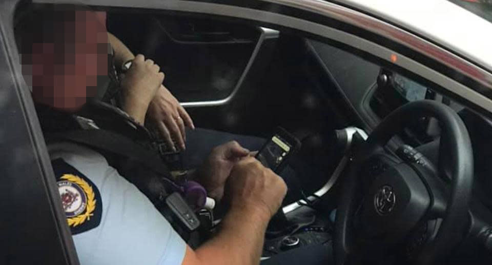 This sheriff was spotted using a mobile phone while behind the wheel of a car stopped at traffic lights. 