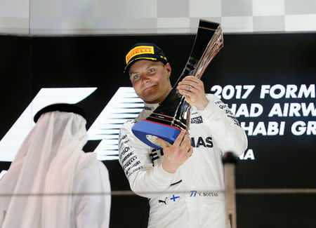 Formula One - Abu Dhabi Grand Prix - Yas Marina circuit, Abu Dhabi, United Arab Emirates - November 26, 2017 Mercedes' Valtteri Bottas celebrates with the trophy after winning the race REUTERS/Hamad I Mohammed