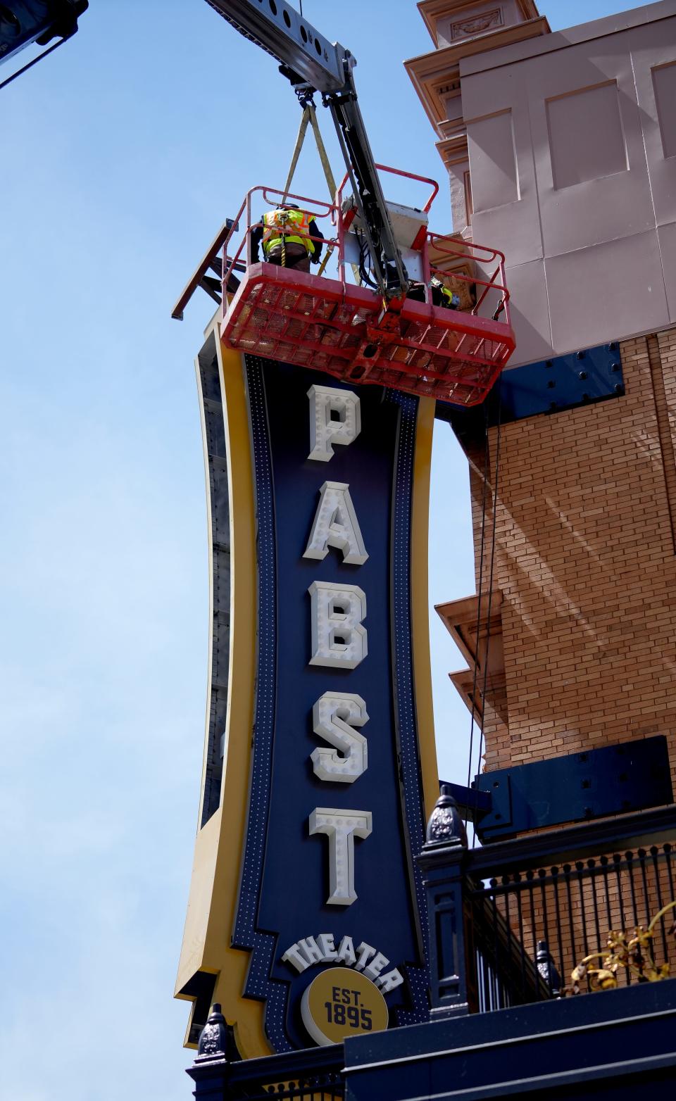 A work crew installs a new blade sign for the Pabst Theater on Monday, May 15 2023  at the corner of corner of Water and Wells Streets  in downtown Milwaukee. The sign is 7’ wide x 27’ tall. The project is expected to take a full day to complete.