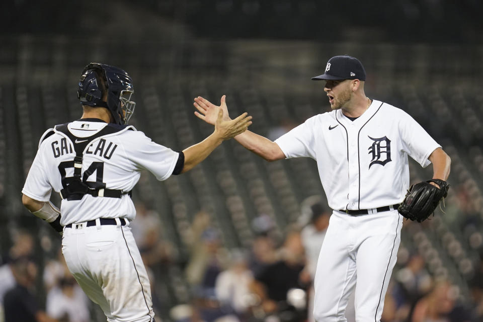 Detroit Tigers catcher Dustin Garneau (64) and pitcher Alex Lange celebrate after the final out in the ninth inning of a baseball game against the Chicago White Sox in Detroit, Monday, Sept. 20, 2021. Detroit won 4-3. (AP Photo/Paul Sancya)