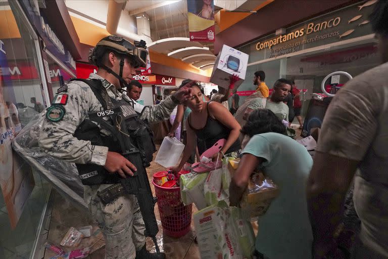Un soldado de la Guardia Nacional Mexicana intenta detener los saqueos en un centro comercial después de que el huracán Otis arrasara Acapulco, México, el miércoles 25 de octubre de 2023