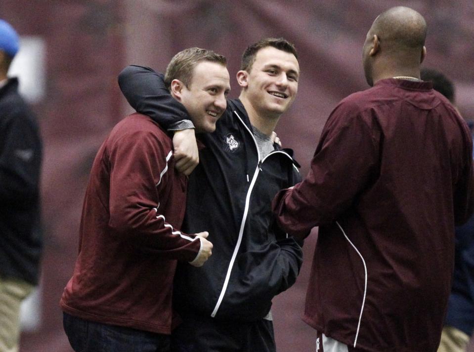 FILE - In this March 5, 2014, file photo, Texas A&M quarterback Johnny Manziel, middle, gives offensive coordinator Jake Spavital a hug during Texas A&M pro day in College Station, Texas. Spavital is now offensive coordinator at Cal. (AP Photo/Patric Schneider, file)