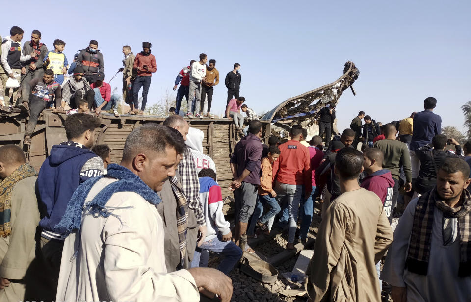 Egyptians look for remains of victims around mangled train carriages at the scene. Source: AP