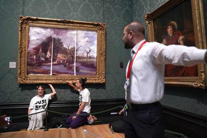 Protesters from the Just Stop Oil climate protest group glue their hands to the frame of John Constable's 