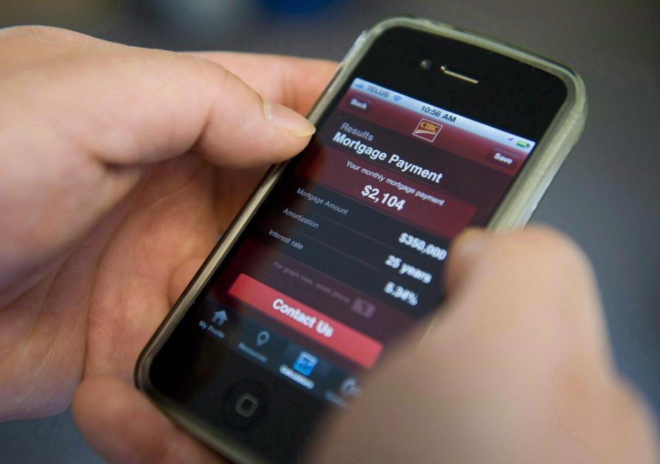 A smart phone user checks their bank account with an online banking app from CIBC in Ottawa on Friday, April 1, 2011. (THE CANADIAN PRESS/Sean Kilpatrick)