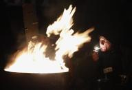 An anti-government protester smokes on the barricade in Kiev February 7, 2014. REUTERS/David Mdzinarishvili