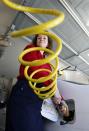 Connie Jones connects the nozzle of a home refueling station to her 2003 natural gas powered Honda Civic in the garage of her home in Chandler, Arizona, October 3, 2013. (REUTERS/Ralph D. Freso)